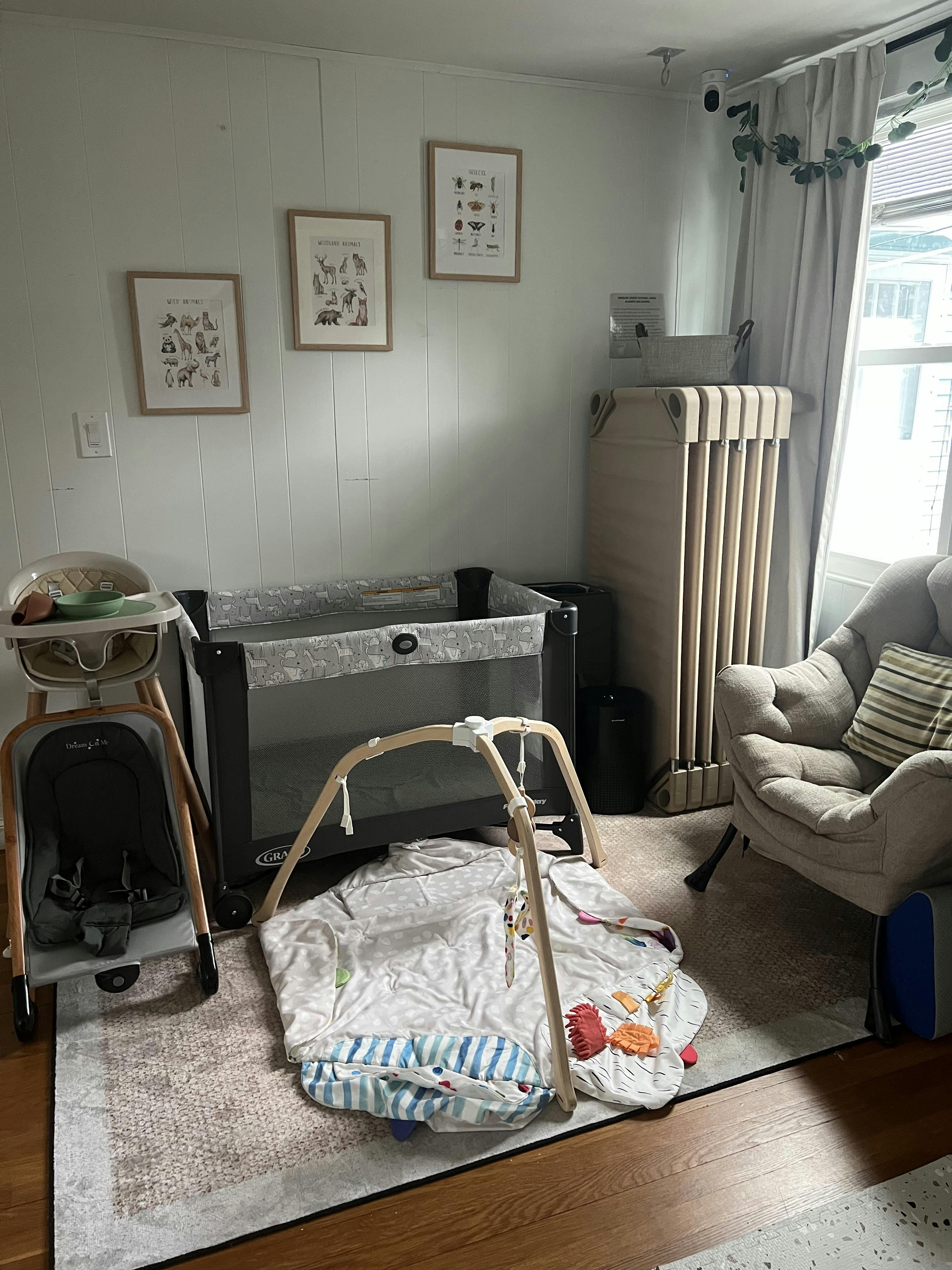 baby play area with a highchair, pack-n-play, baby gym mat, and chair