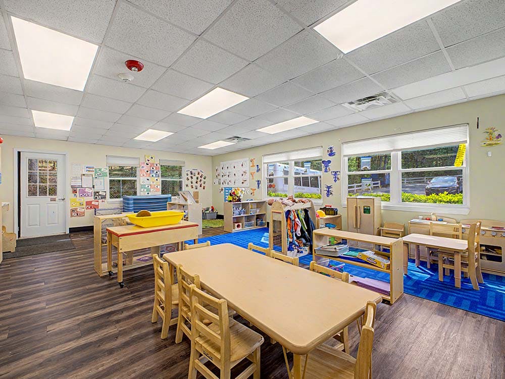 Classroom with child-sized tables and chairs, toys, and learning materials