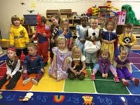 Children in costumes posing in a classroom