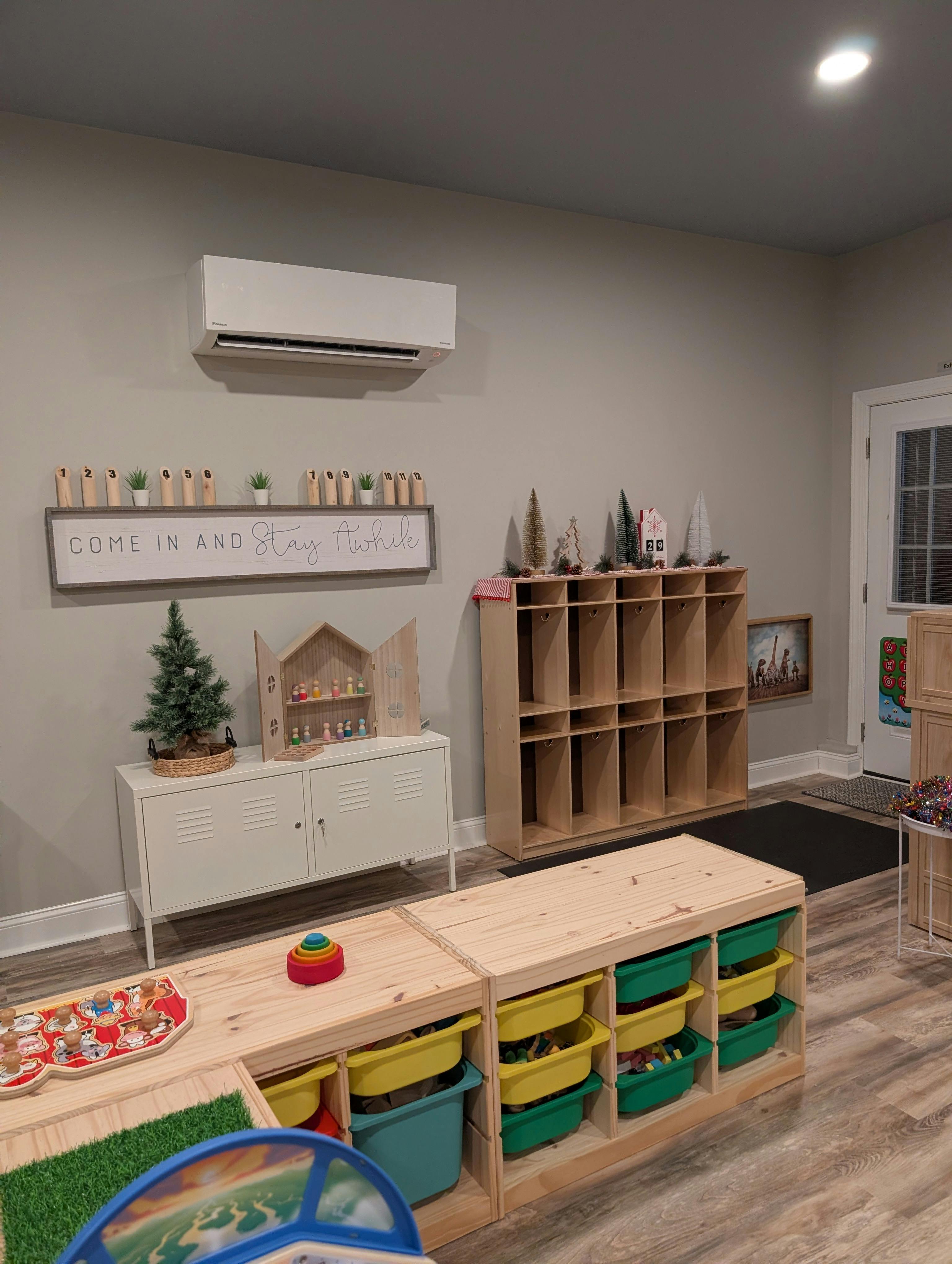 Playroom with toy storage, shelves, and small Christmas tree