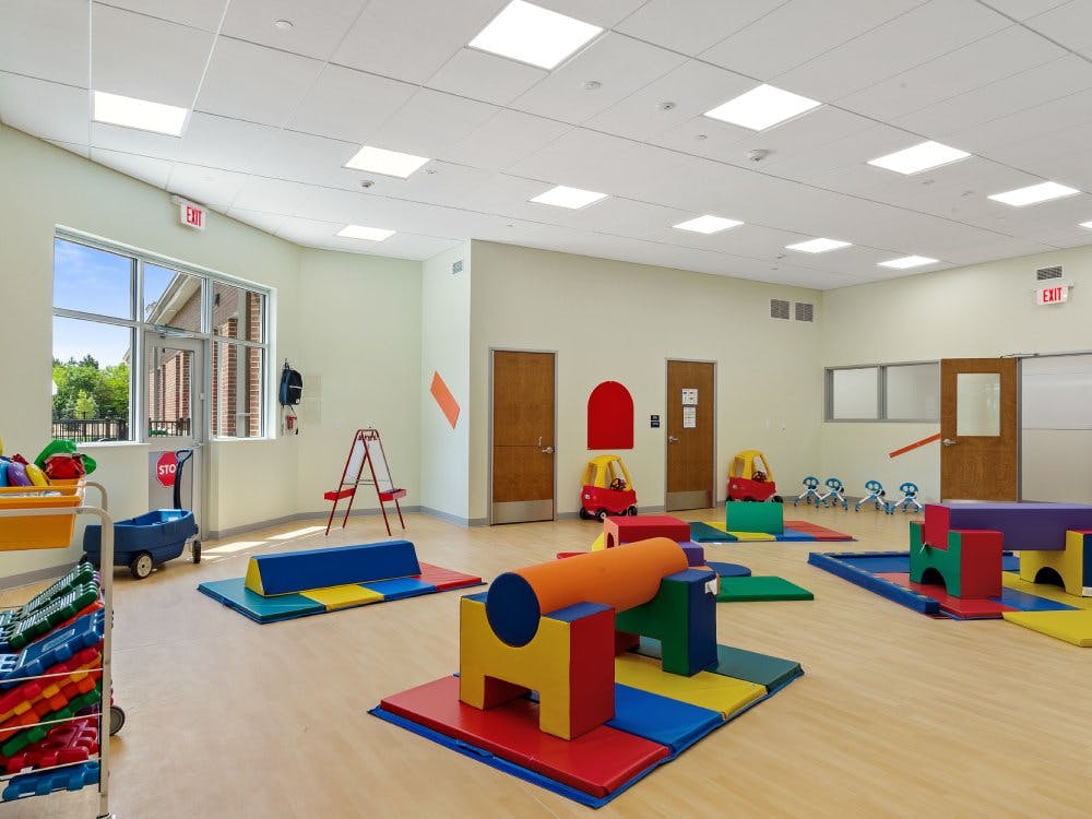 Playroom with colorful soft play equipment and ride-on toys