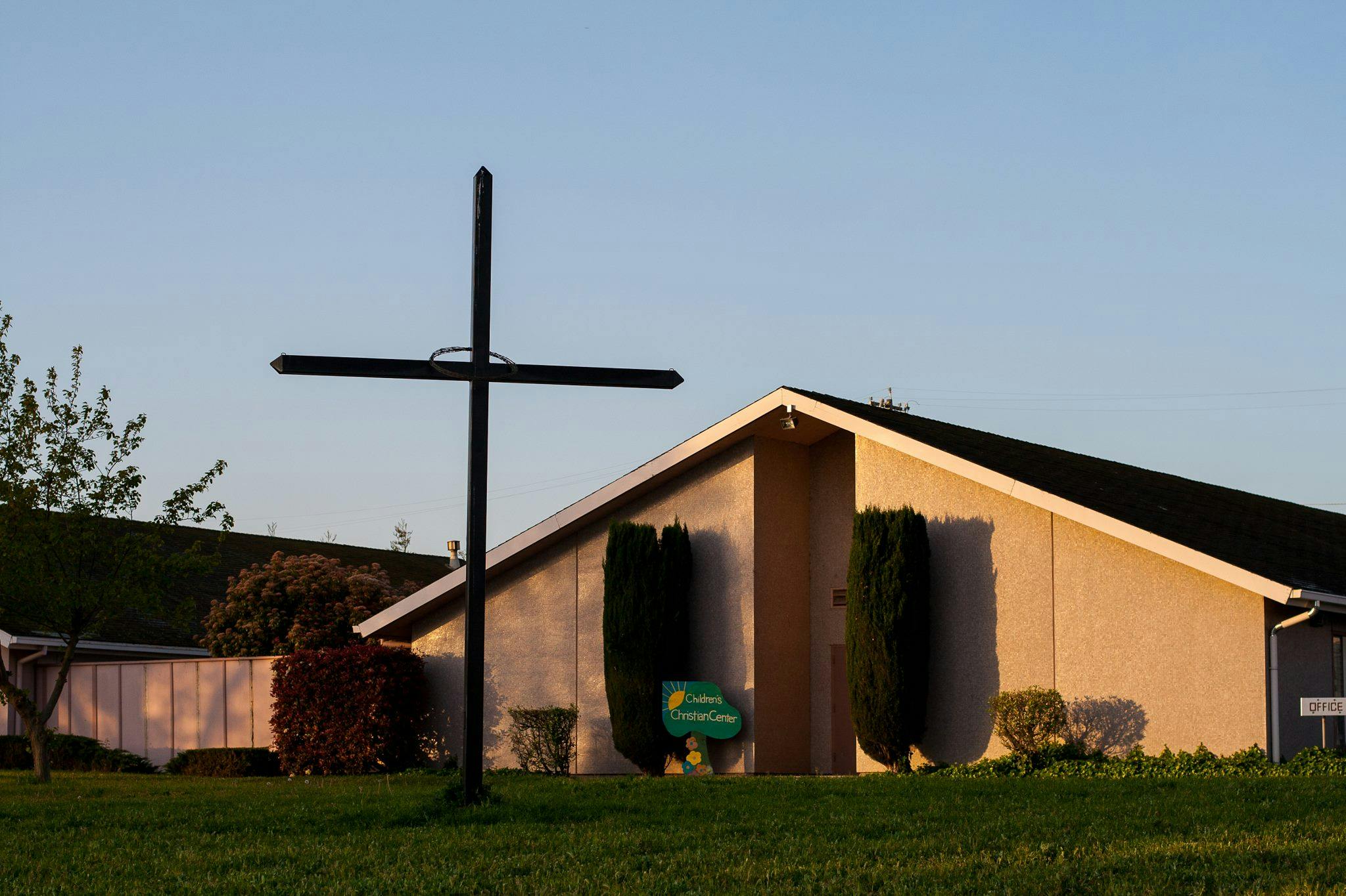 Cross in front of a building with a peaked roof