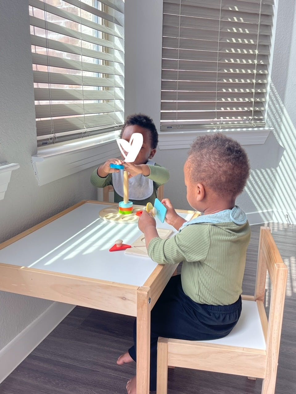 Two children playing with toys at a small table