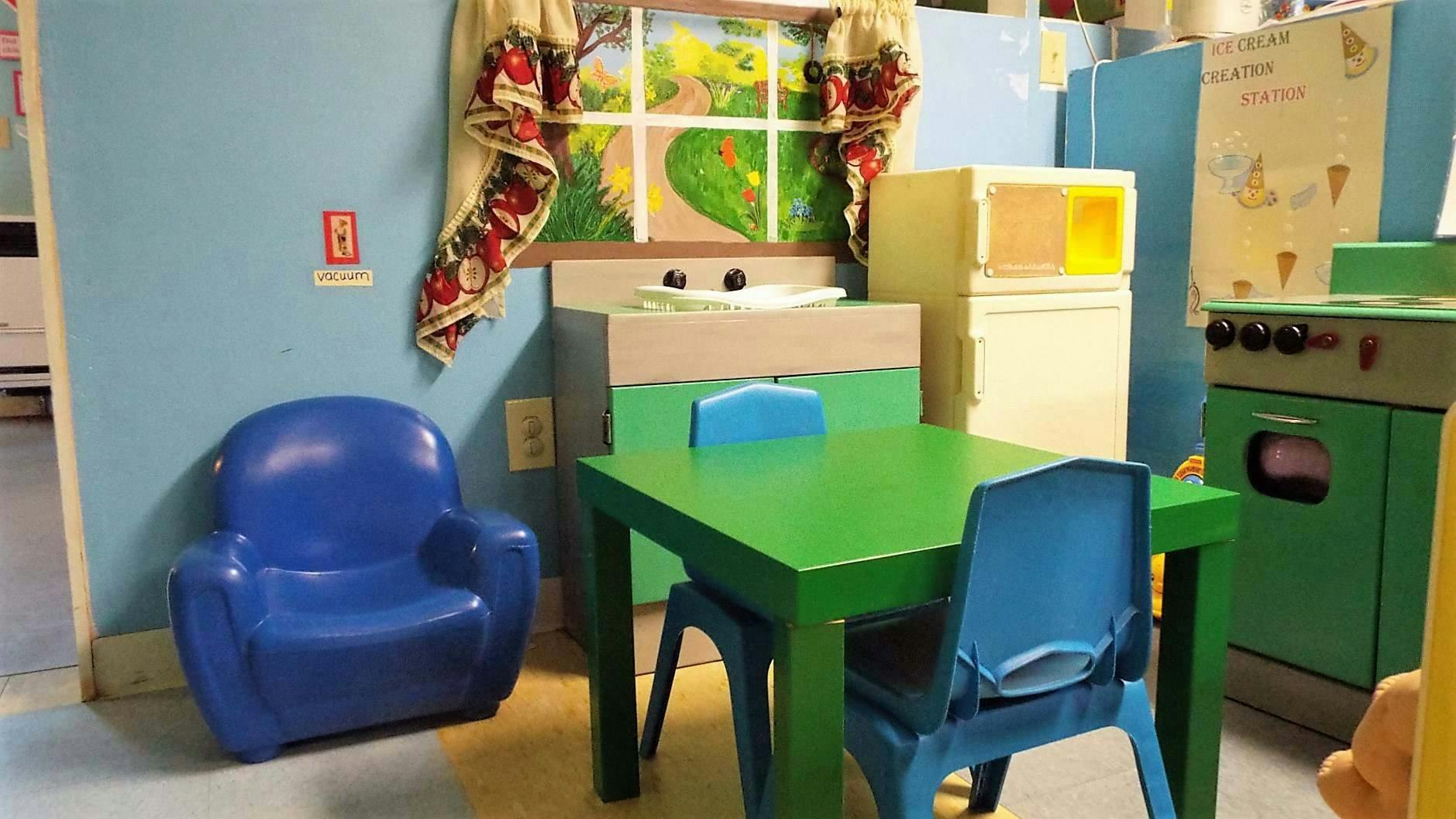 Play kitchen with green table and blue chairs
