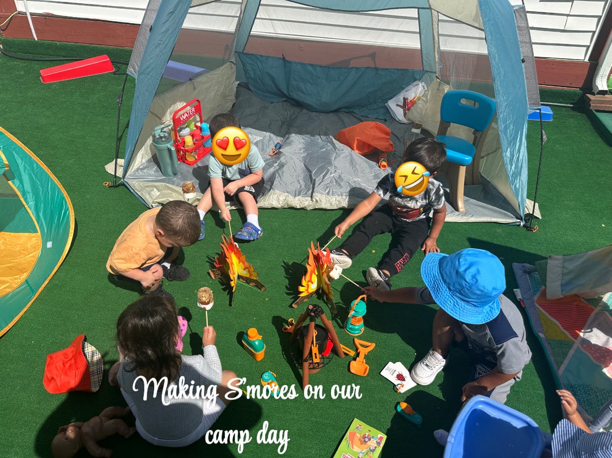 Children playing around toy campfires with a tent in the background