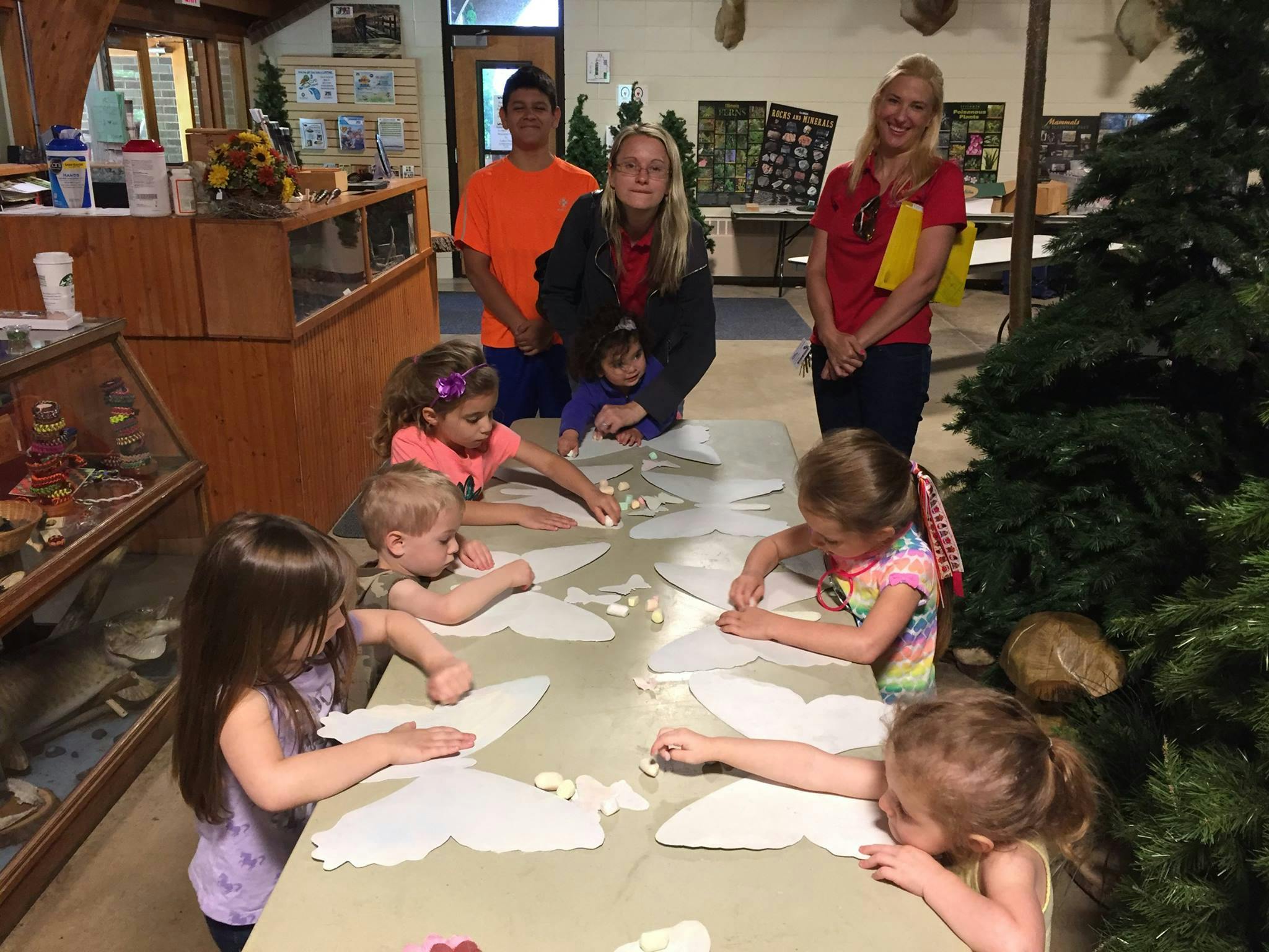 Adults and children gathered around a table doing an activity