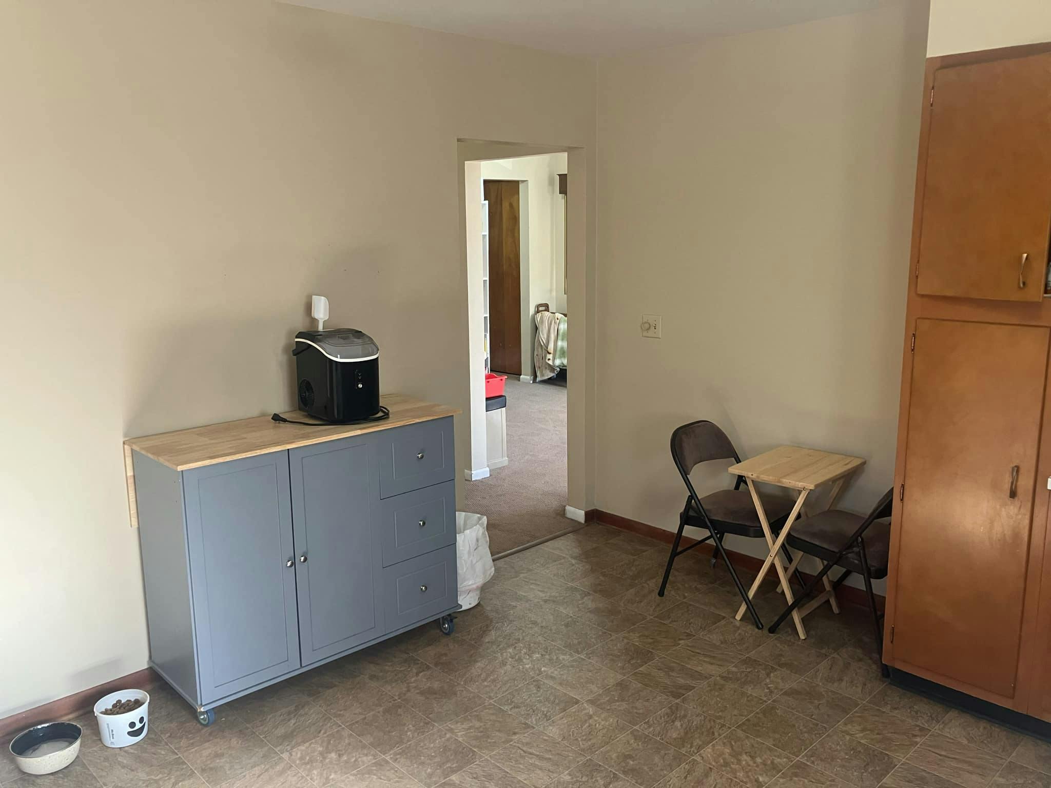 Small room with a gray cabinet, coffee maker, and a small table with two chairs