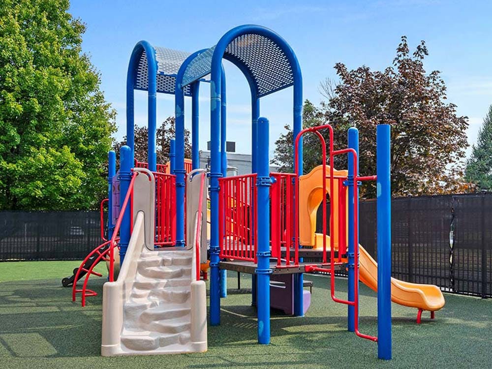 Colorful playground structure with slides and climbing areas on a green turf