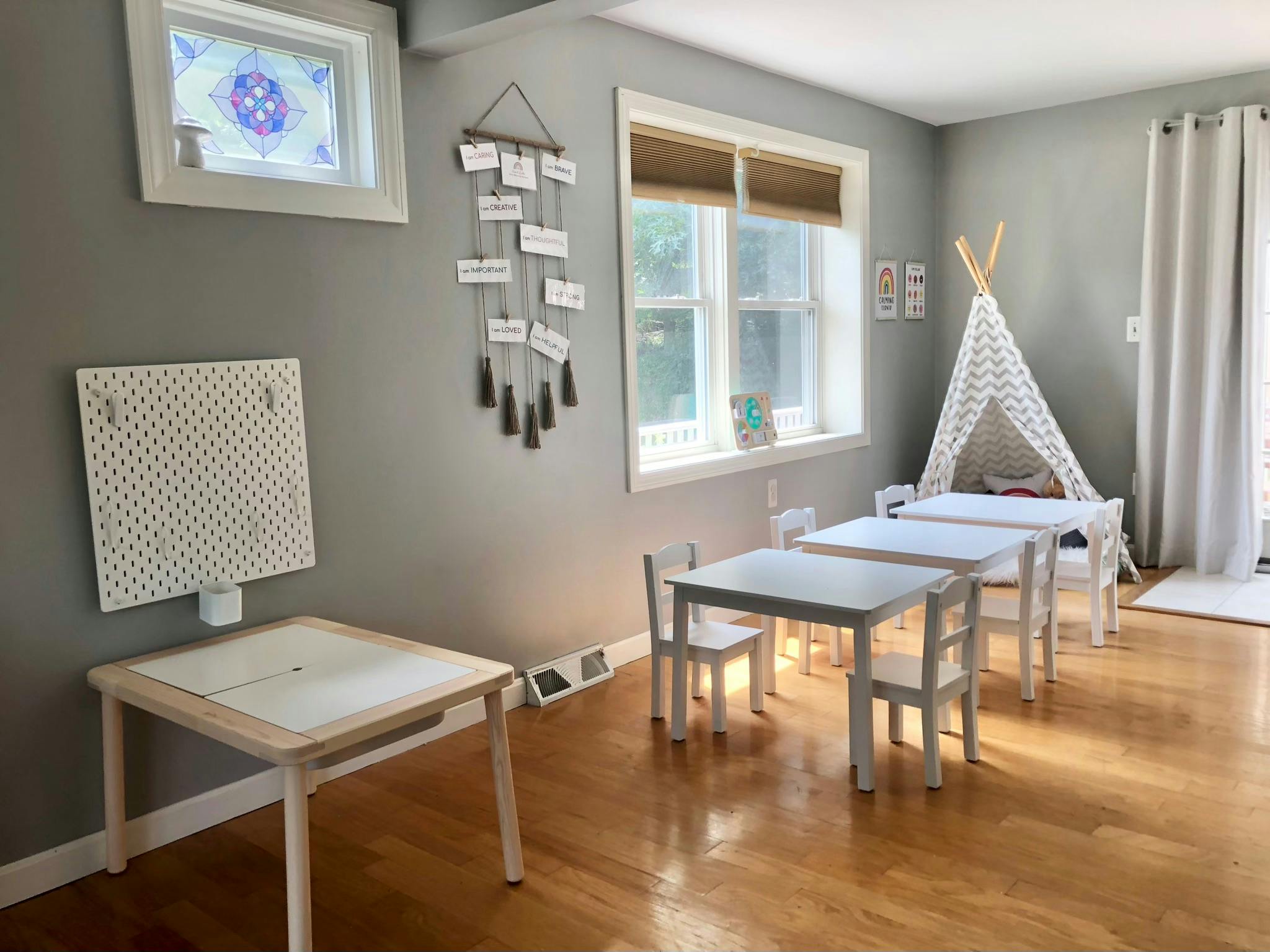 Children's play area with small tables, chairs, and a teepee