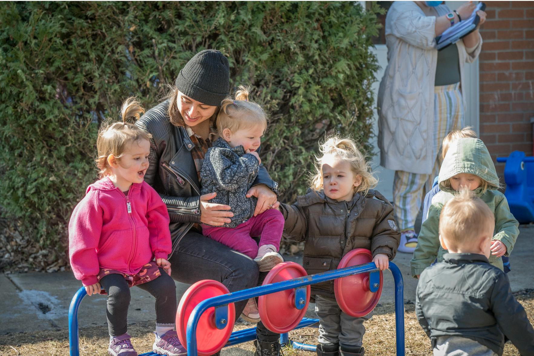 Person with three children on playground equipment