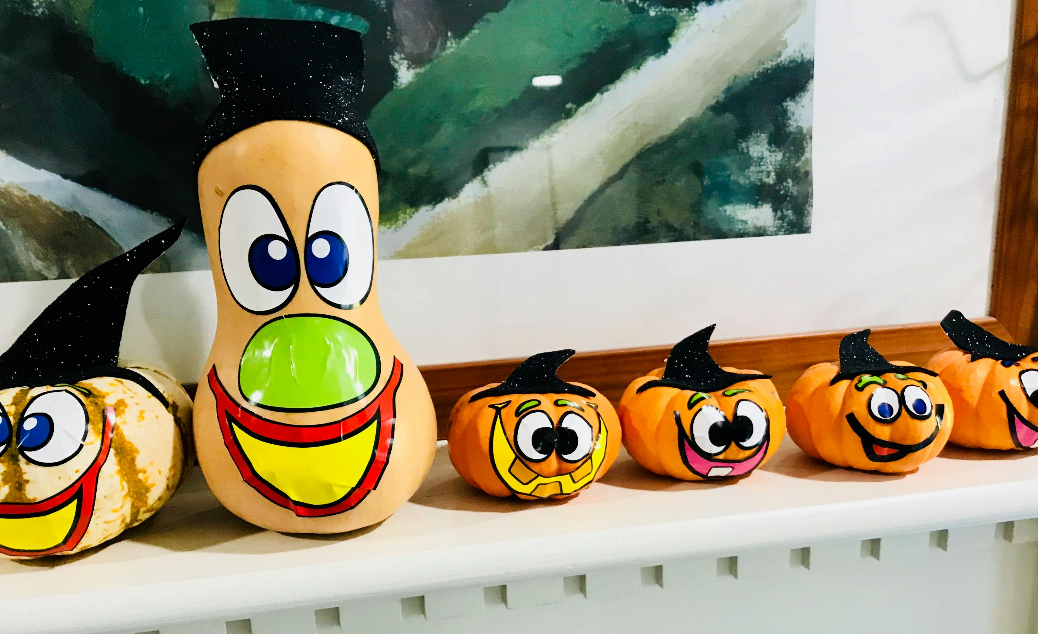 Painted gourds and mini pumpkins with faces and witch hats