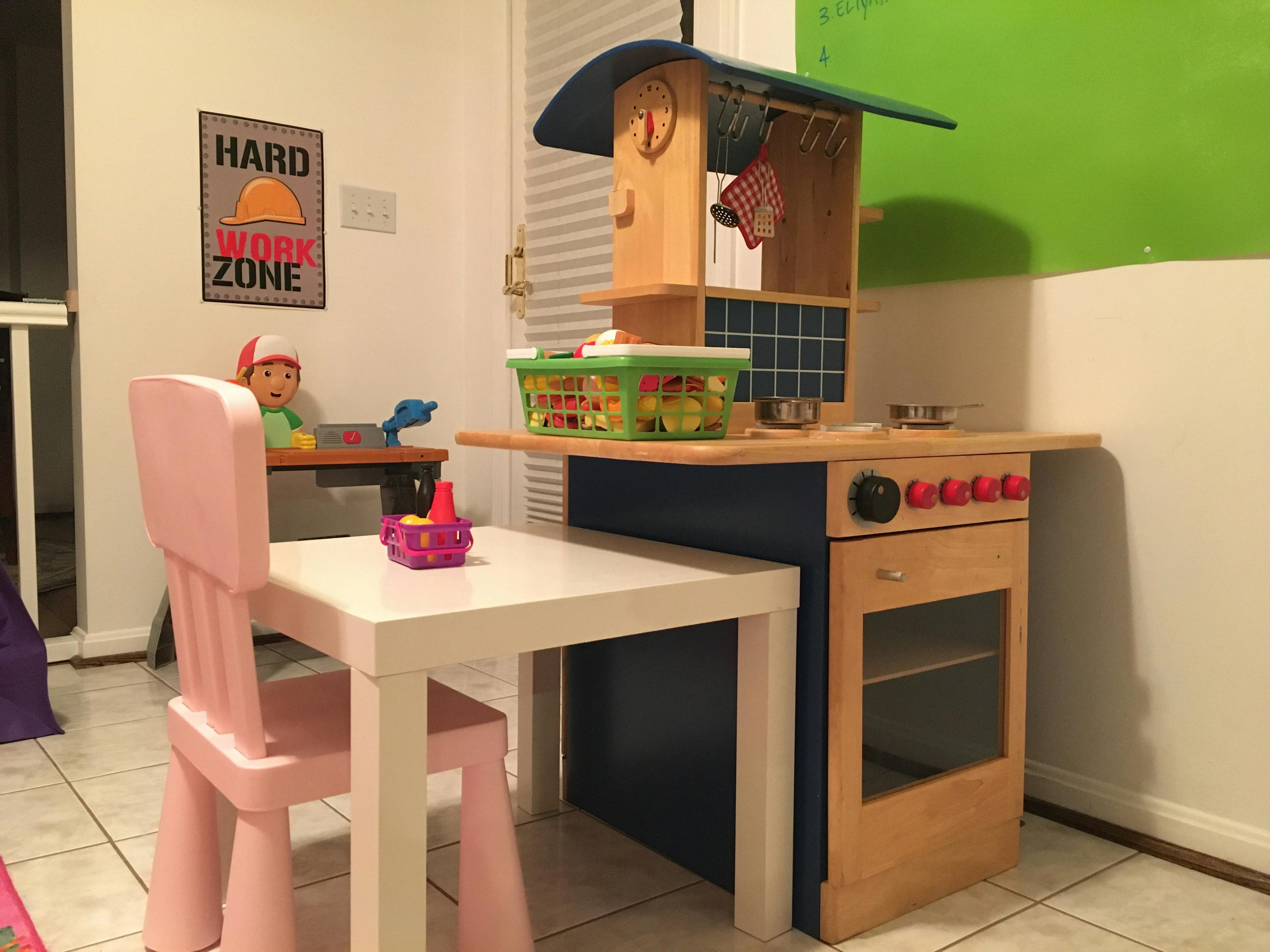 Child's play kitchen with a small table and chair