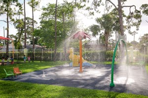 Water spraying from a splash pad with play equipment