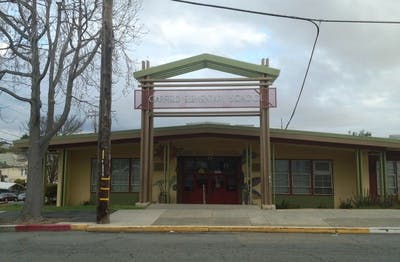 Building with an ornate entrance structure and a sign above the doorway