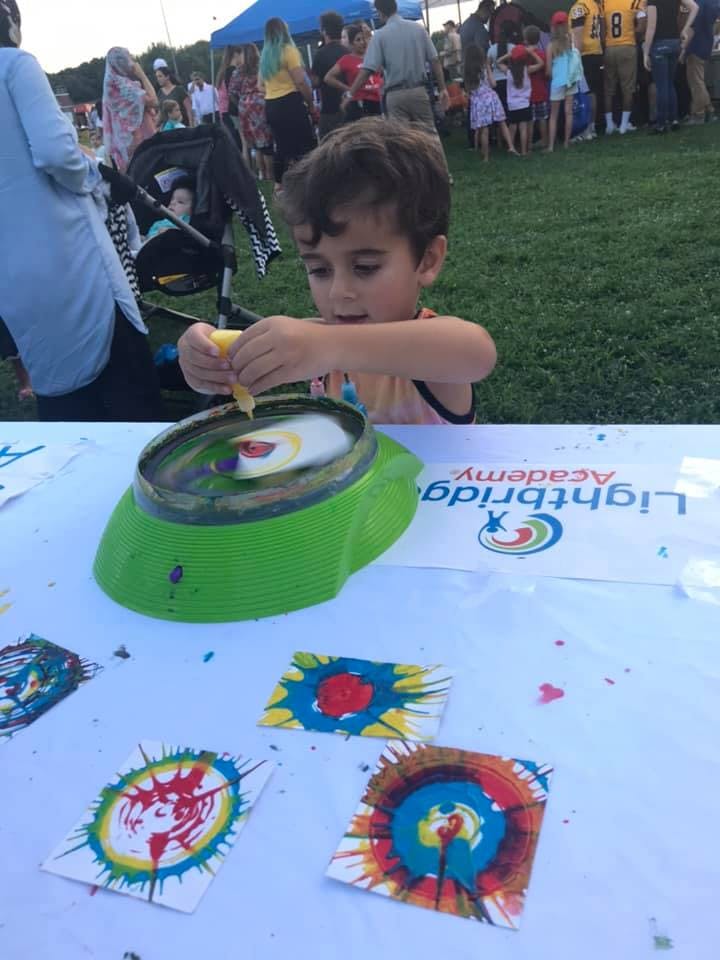 Child making spin art at a table