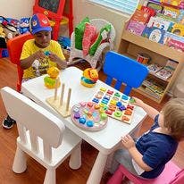 Two children playing with educational toys at a small table