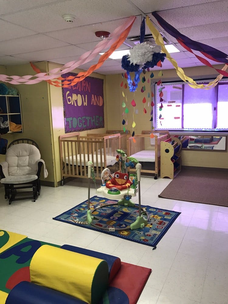 Nursery room with cribs, play mat, and baby bouncer