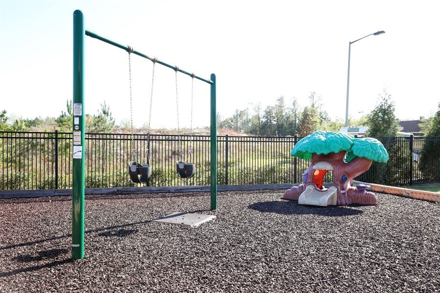 Swings and a tree-shaped play structure on a playground