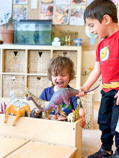 Two children playing with animal toys