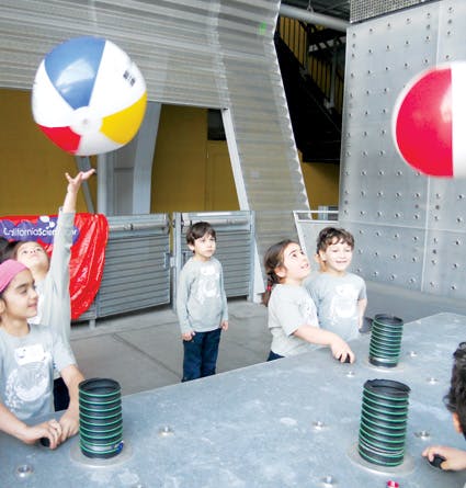 Children playing with beach balls indoors