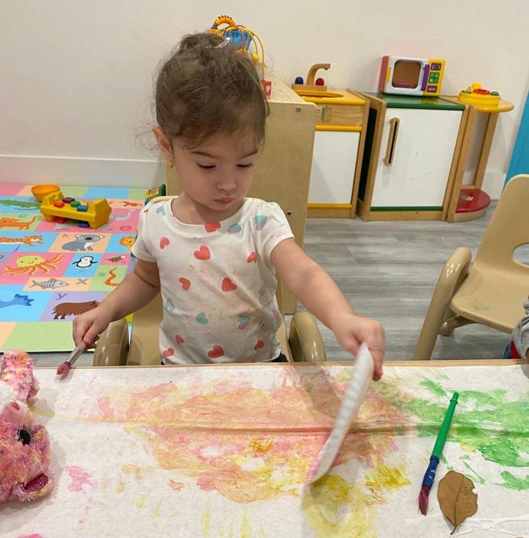 Child painting on paper at a table