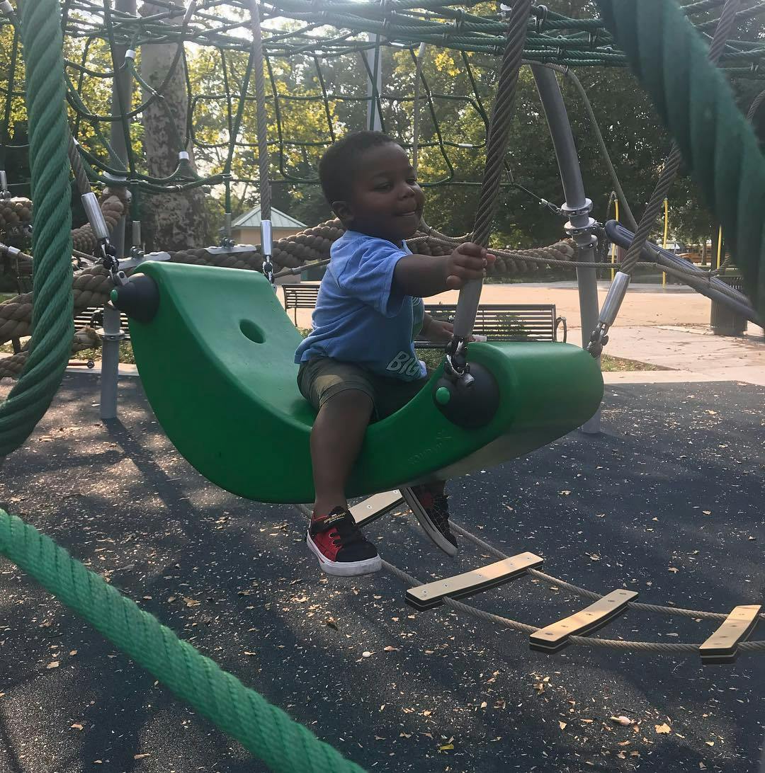Child on a green swing at a playground