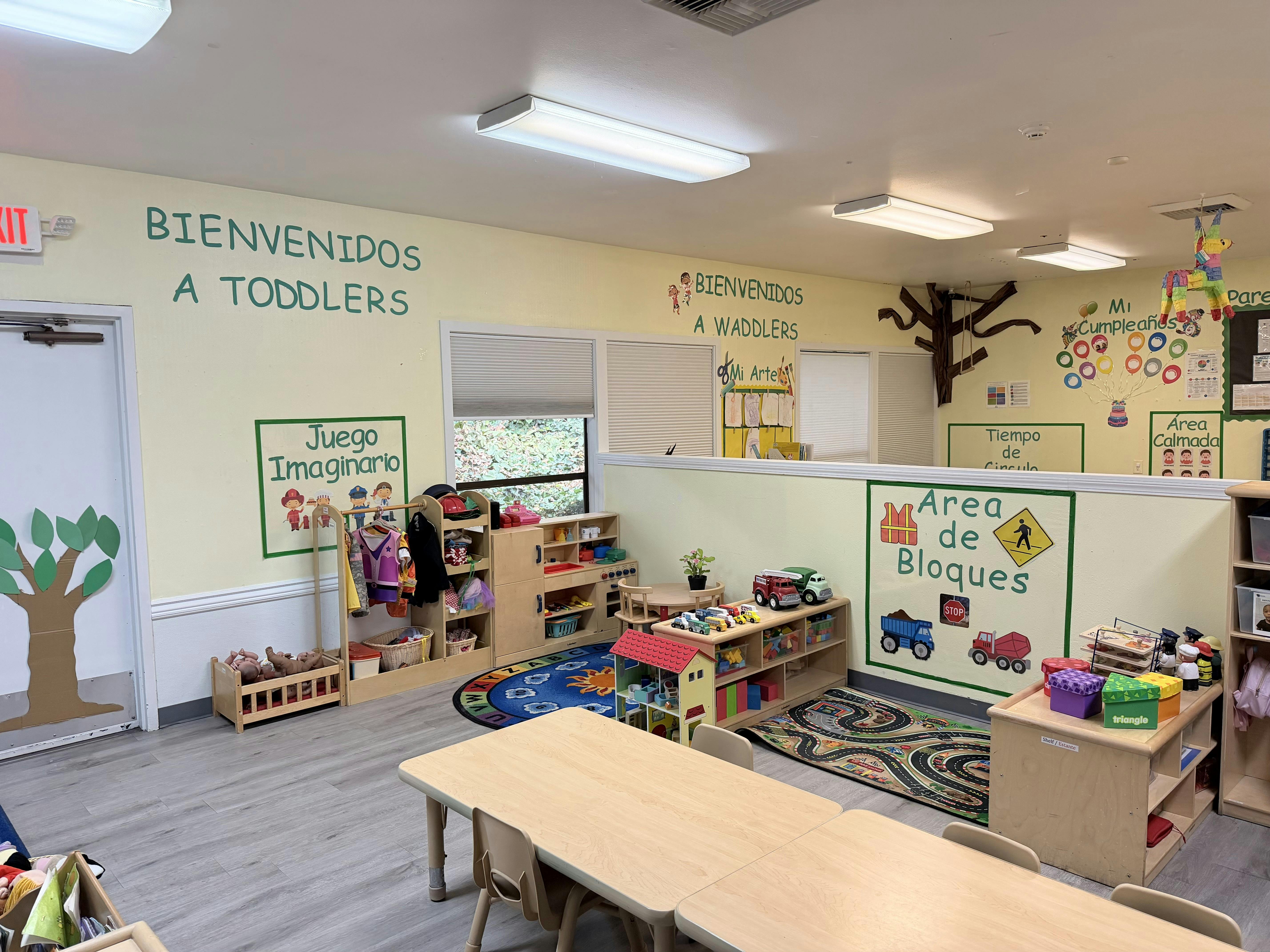 Classroom interior for young children featuring play areas and educational signs