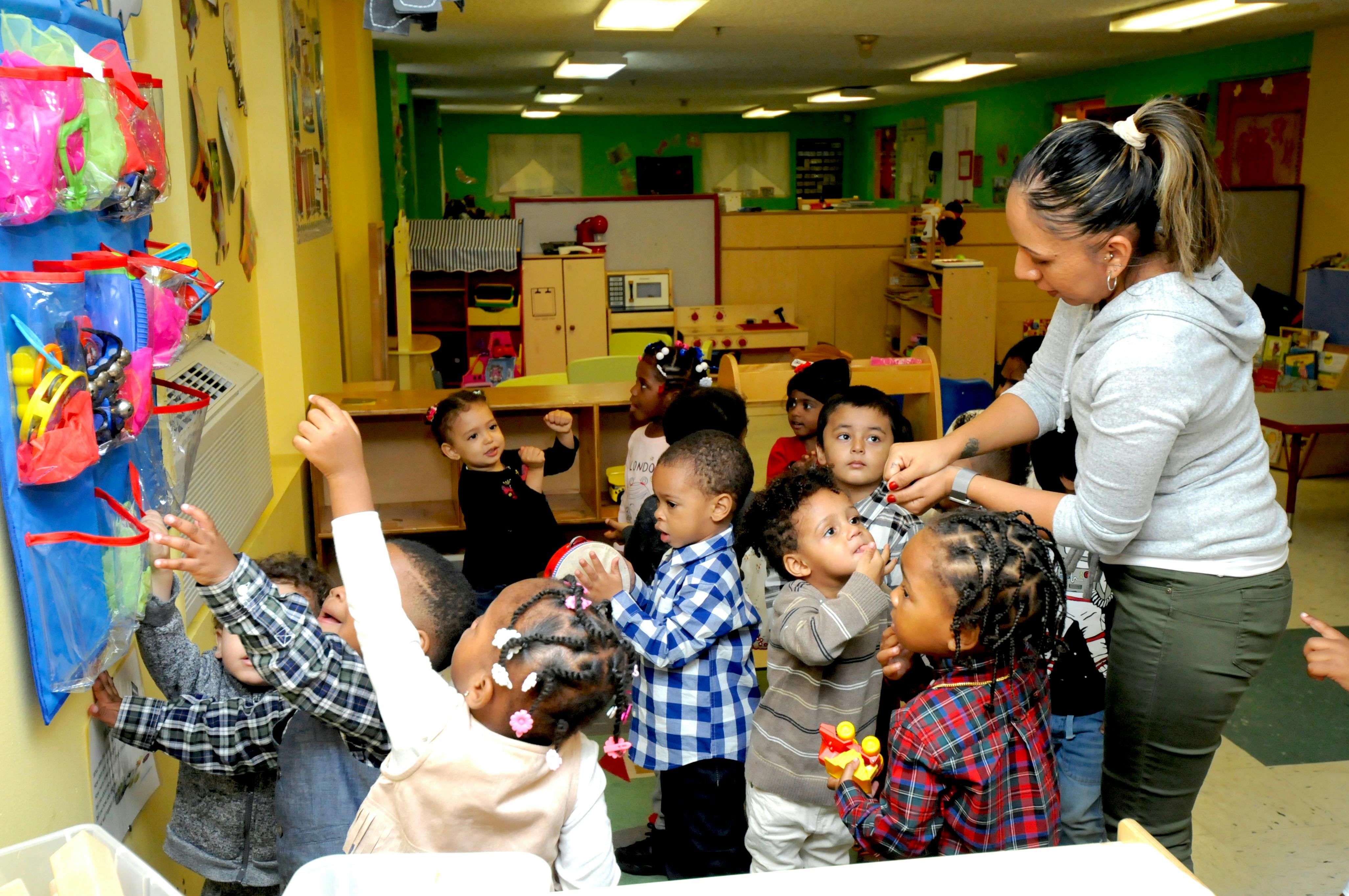 Adult person interacting with children in a classroom