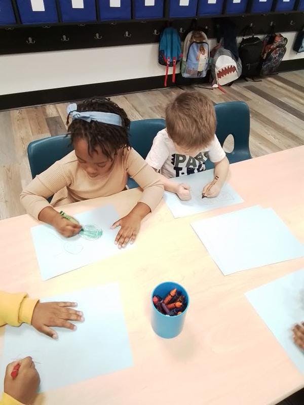 Children drawing at a table in a classroom