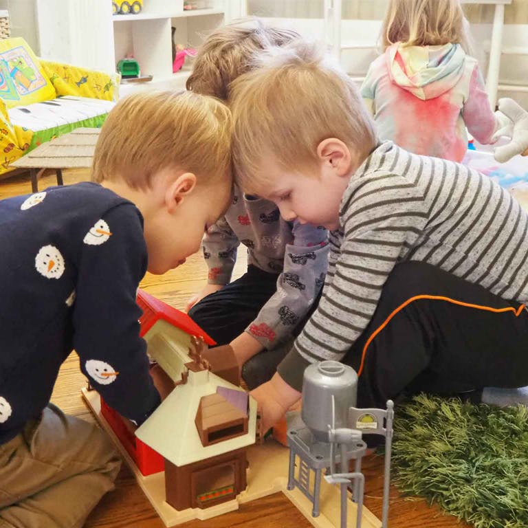 Three children playing with toys on the floor