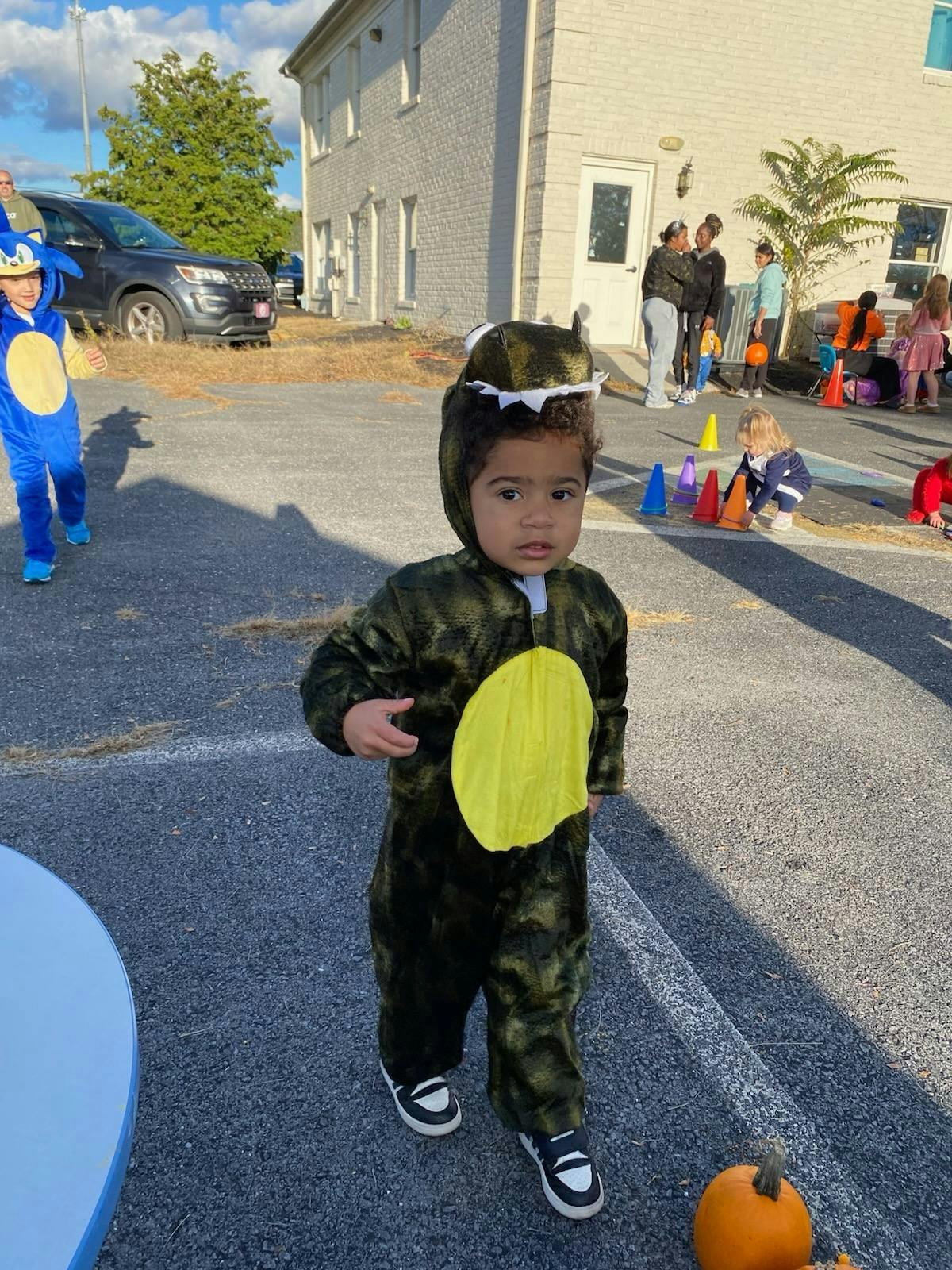 Child in a dinosaur costume walking outdoors
