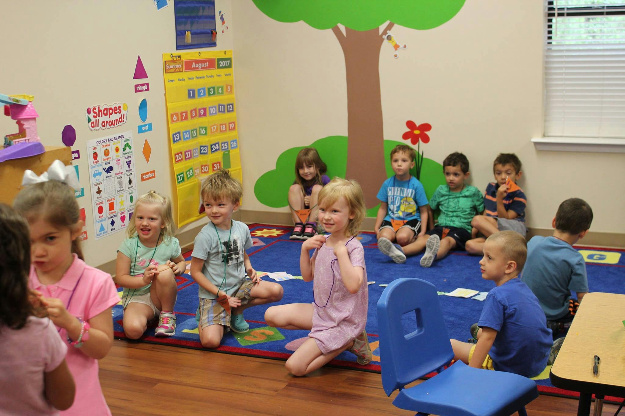 Children sitting on a rug in a classroom
