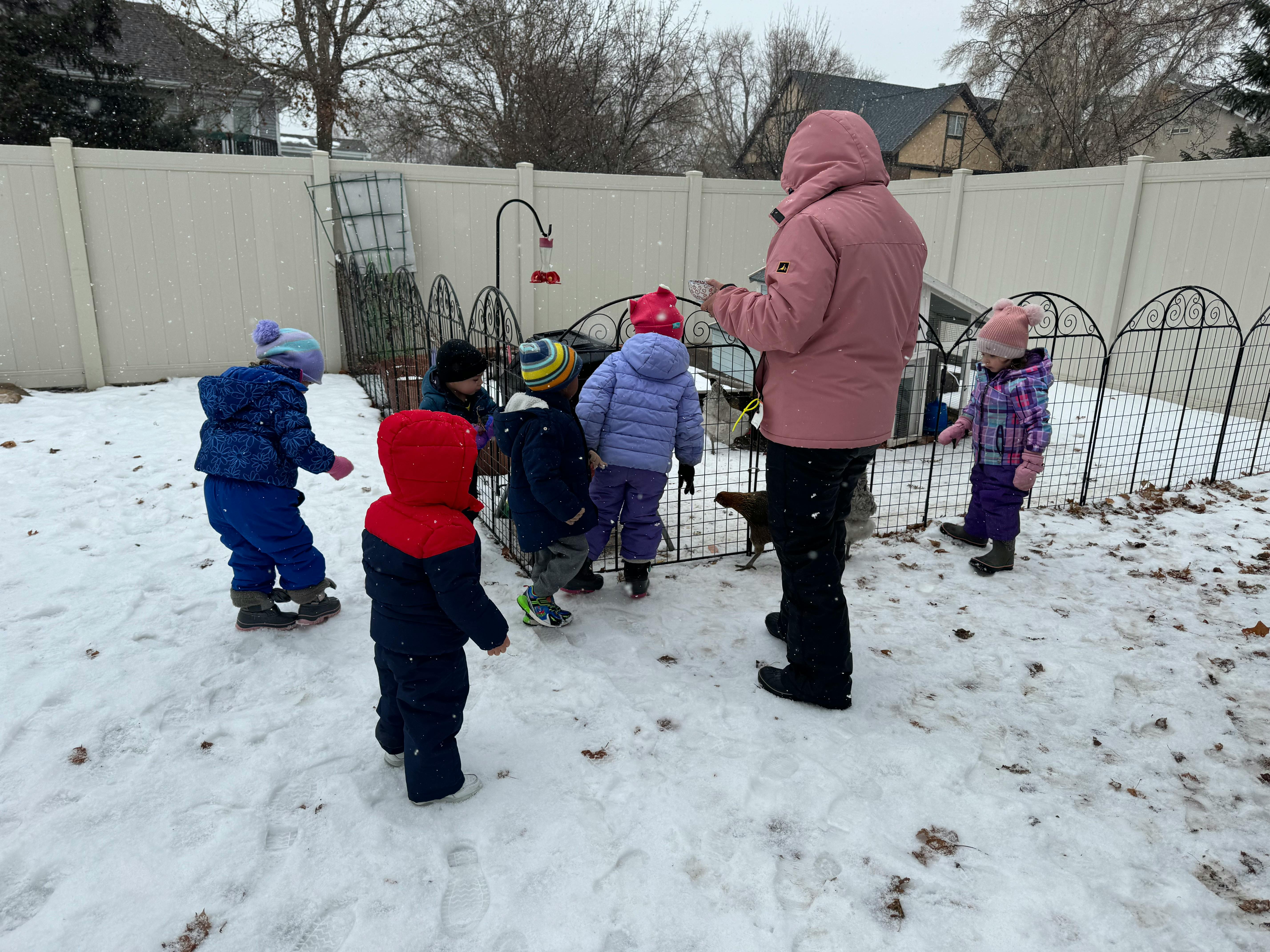 Adult and children in winter clothing standing in snow