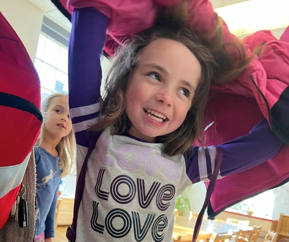 Child in a white shirt with "LOVE LOVE" text, another child in background