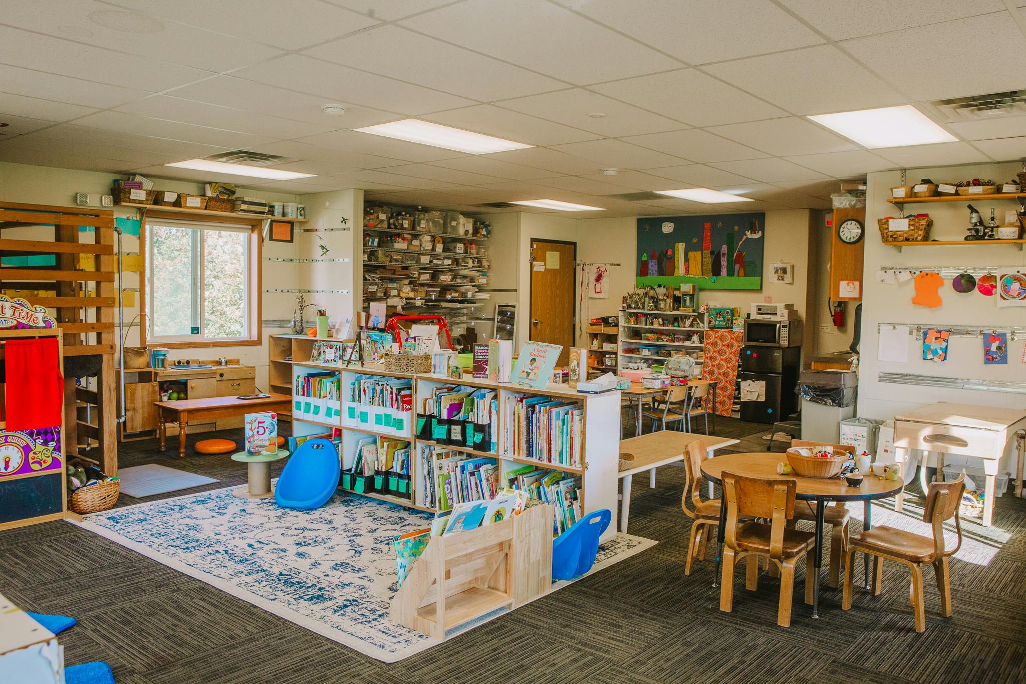 Classroom with bookshelves, tables, and chairs