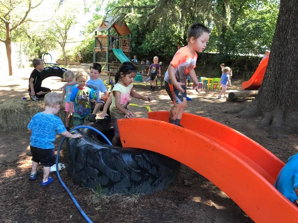 Children playing on a playground with slides and tires