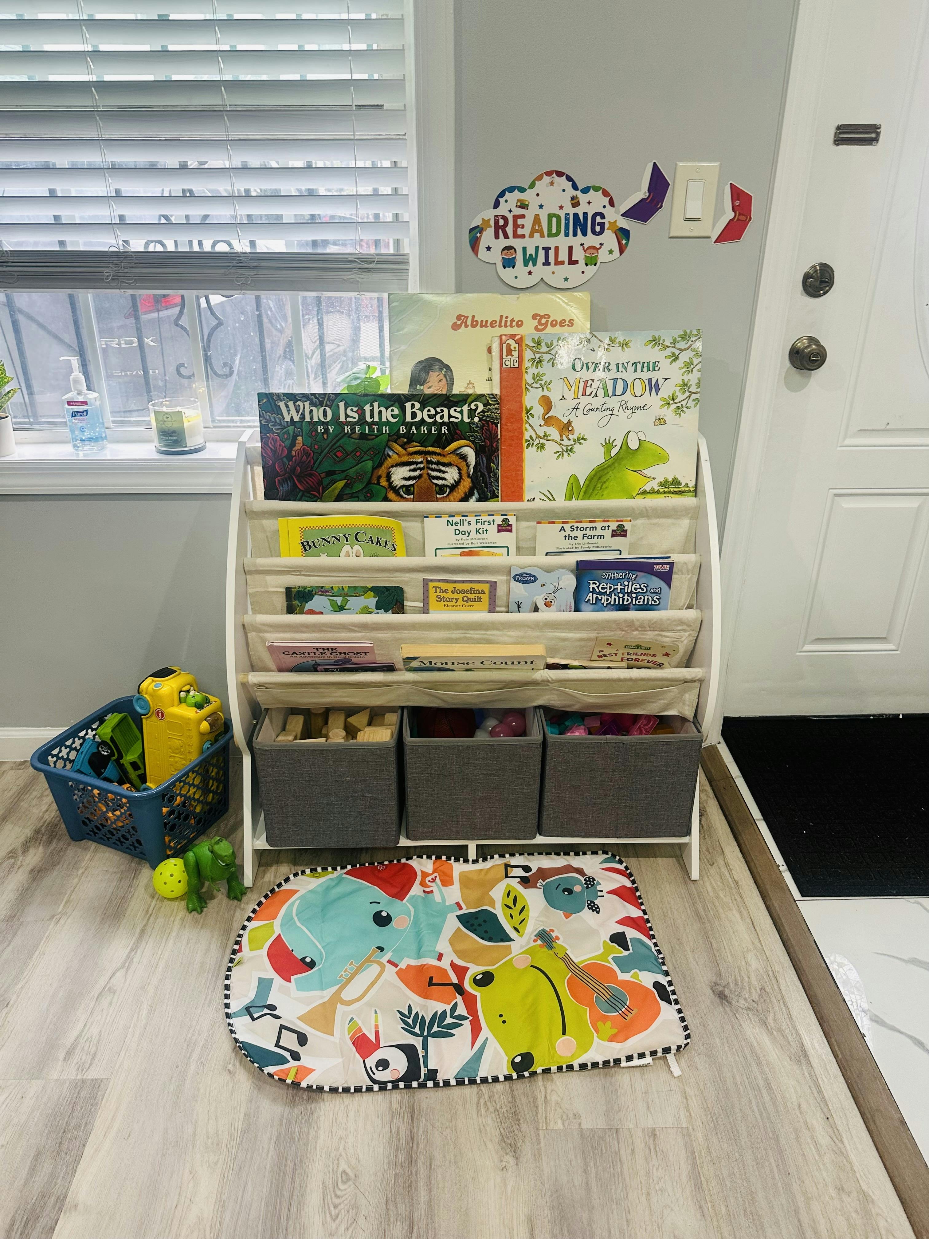Child's bookshelf with books and storage bins, colorful playmat on the floor