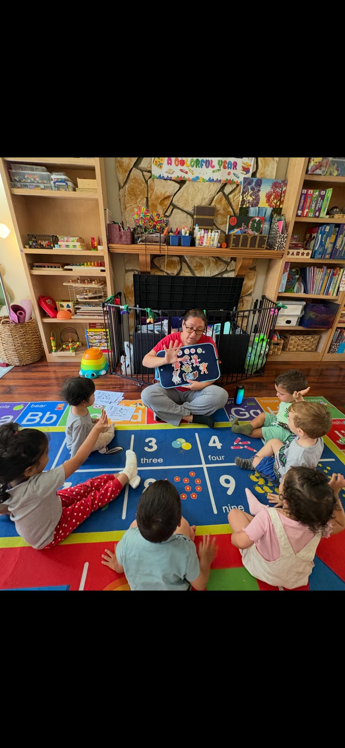 A person sitting on a rug with children for a classroom learning activity
