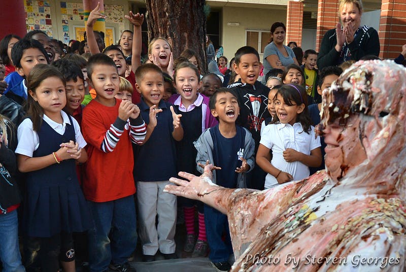 Children watching a person covered in pie filling