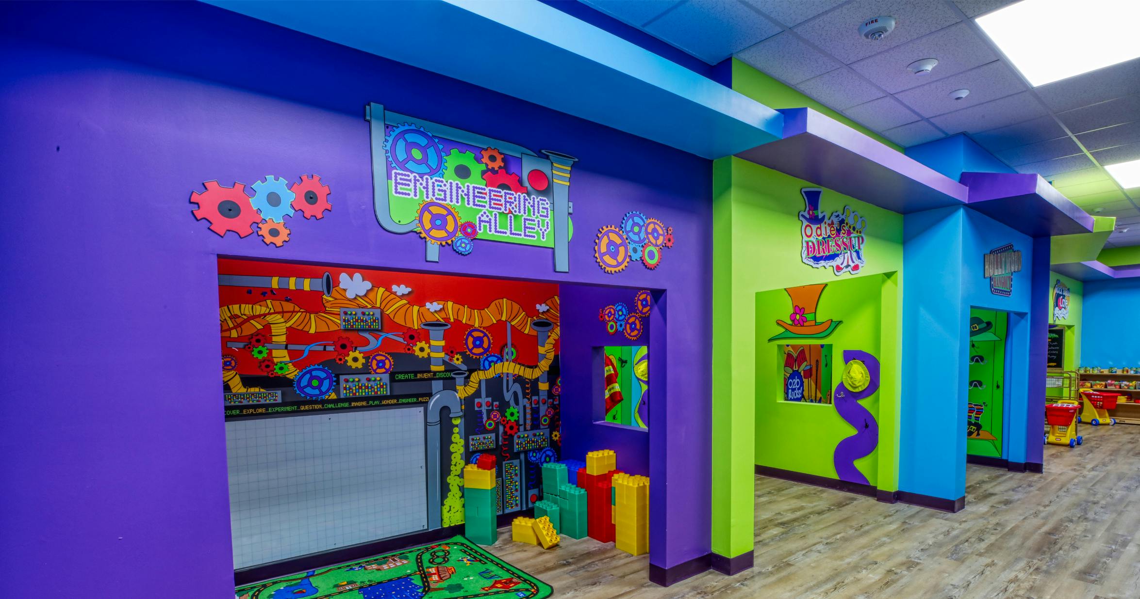 Colorful playroom with 'Engineering Alley' and 'Odie's Dressup' signs