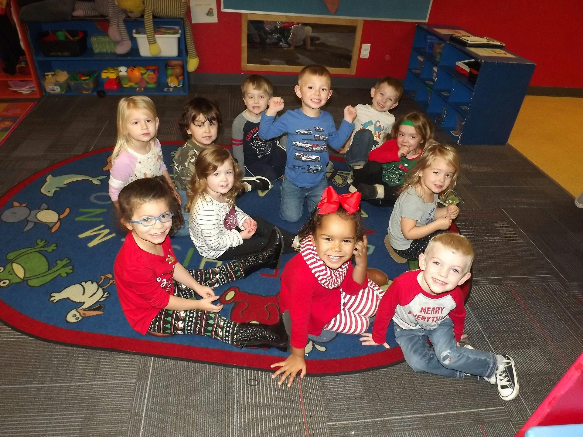 Group of children sitting on a rug in a classroom