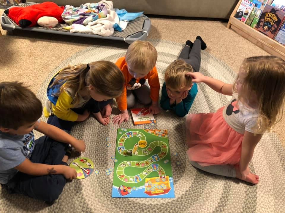 Children playing a board game on the floor