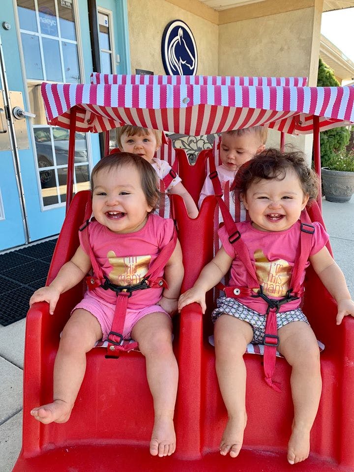 Four children in a red and white striped wagon