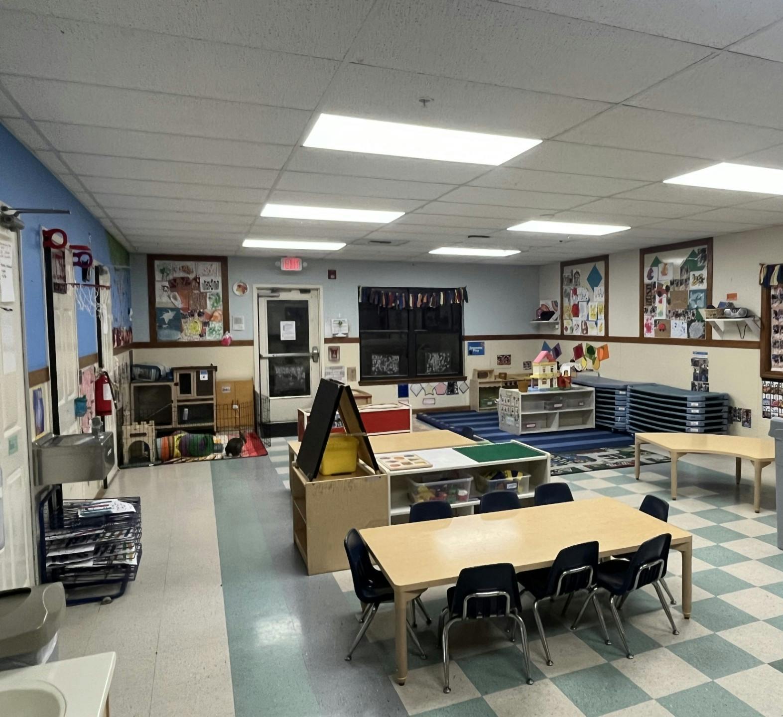 An empty classroom with tables, chairs, and colorful decorations