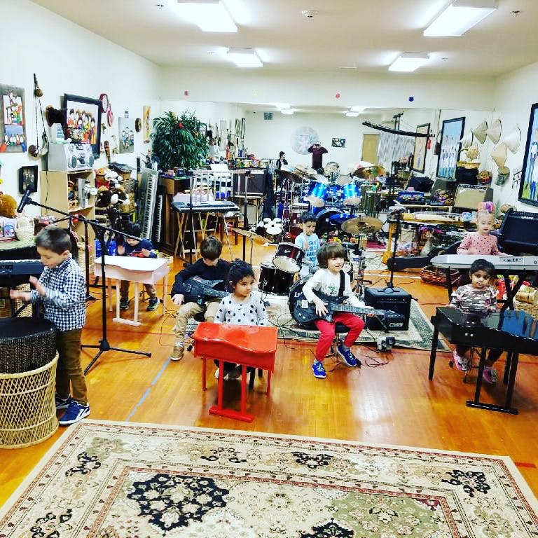 Children playing musical instruments in a room