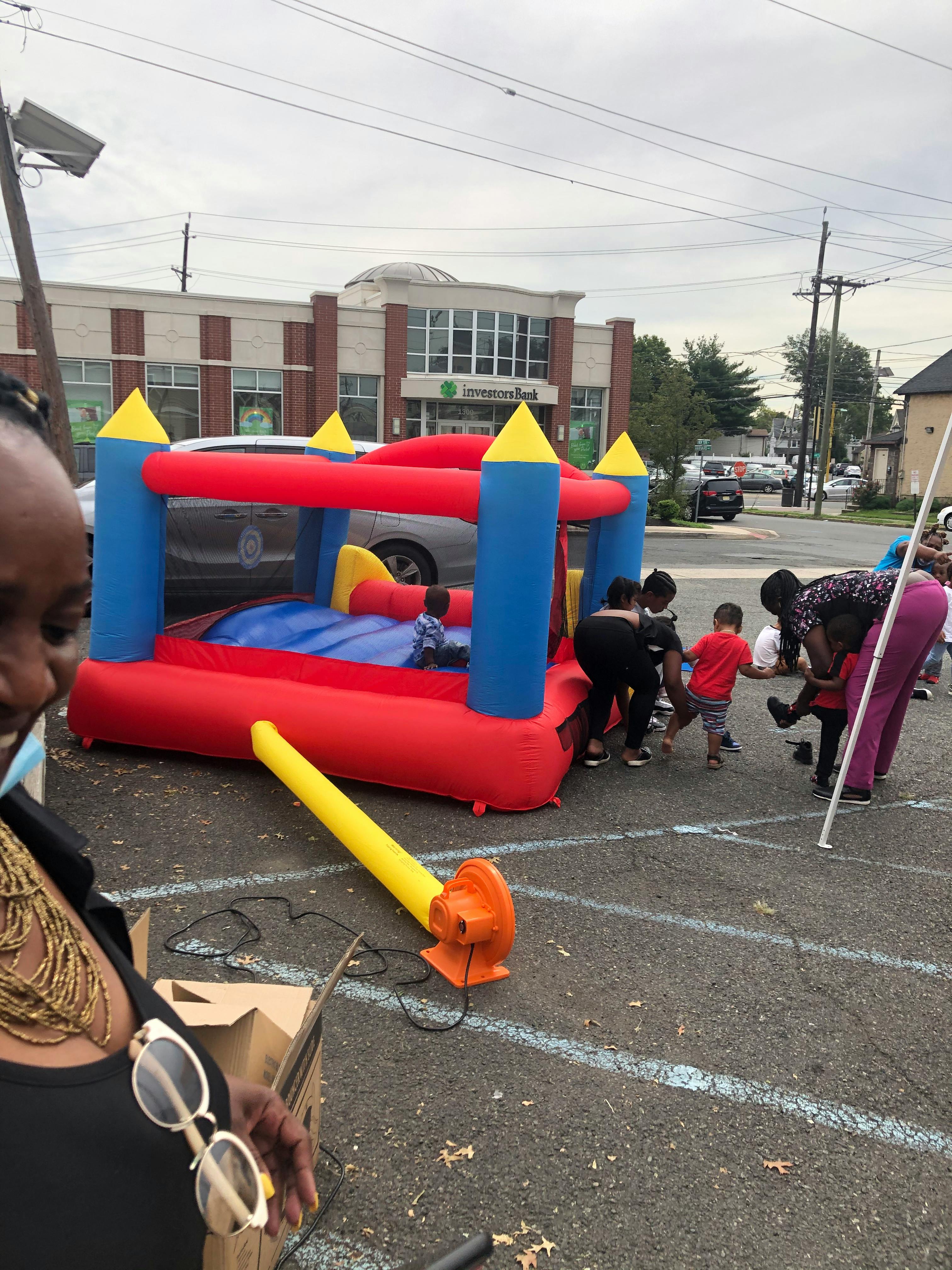 People and children around an inflatable bounce house