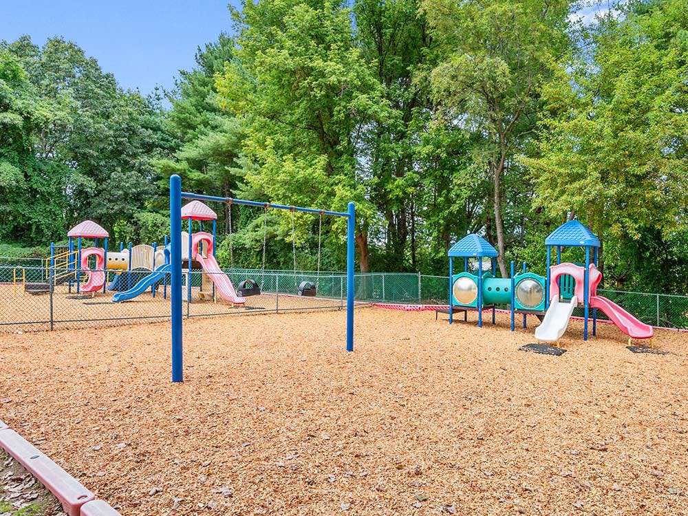 Colorful empty playground with slides and swings on wood chip ground