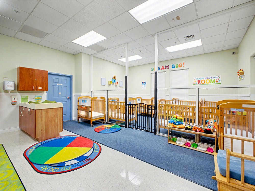 Cribs and a changing station in a nursery room