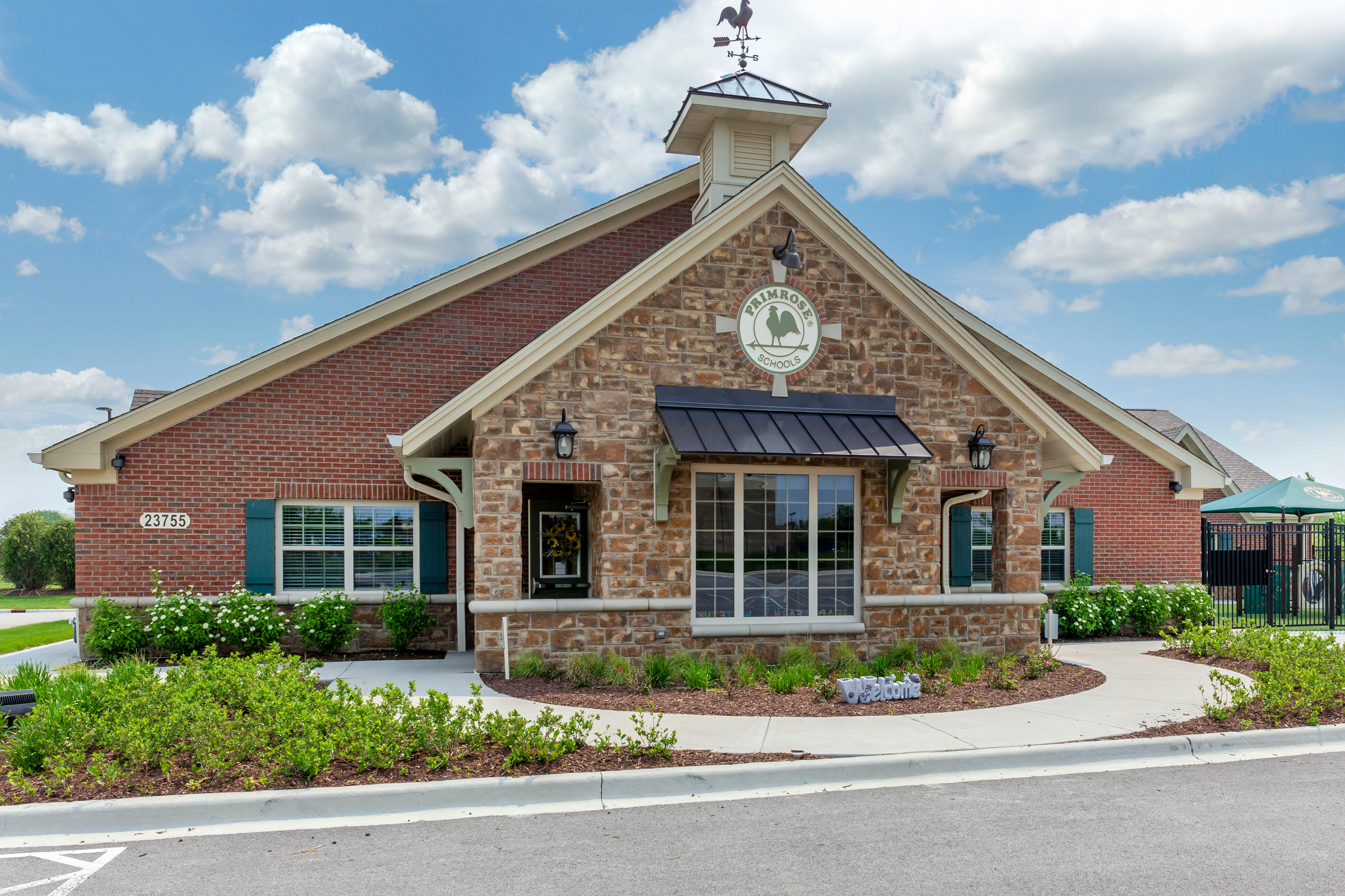 Primrose School building exterior with brick and stone, rooster weathervane