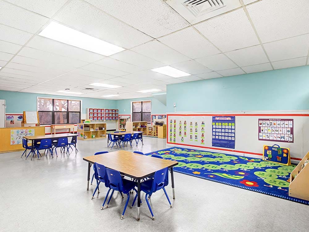 Empty colorful preschool classroom with tables and chairs
